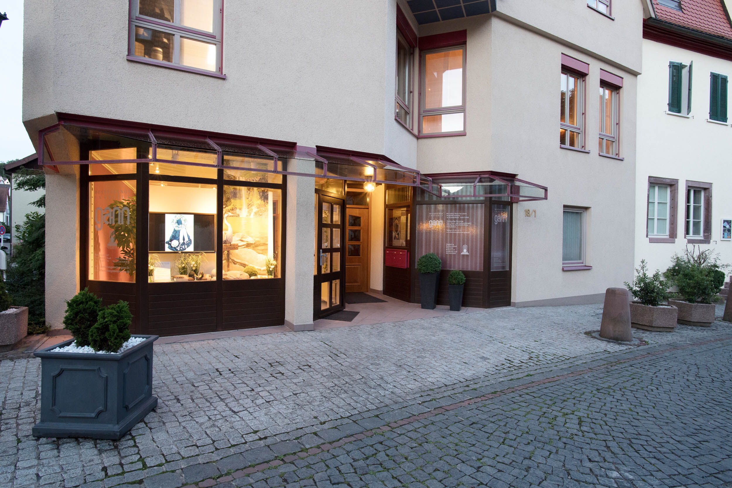 Außenansicht vom Bestattungsinstitut Gann in Weil der Stadt mit beleuchtetem Schaufenster