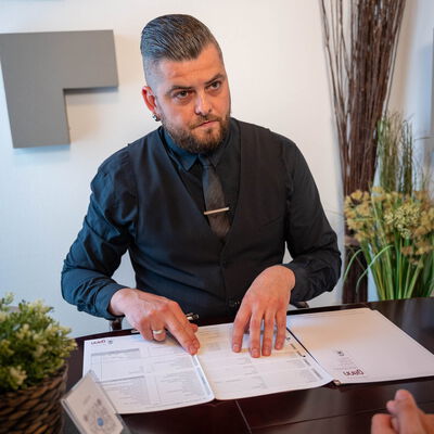 Mitarbeiter vom Bestattungsinstitut Gann in Weil der Stadt mit Formularen im Beratungsgespräch